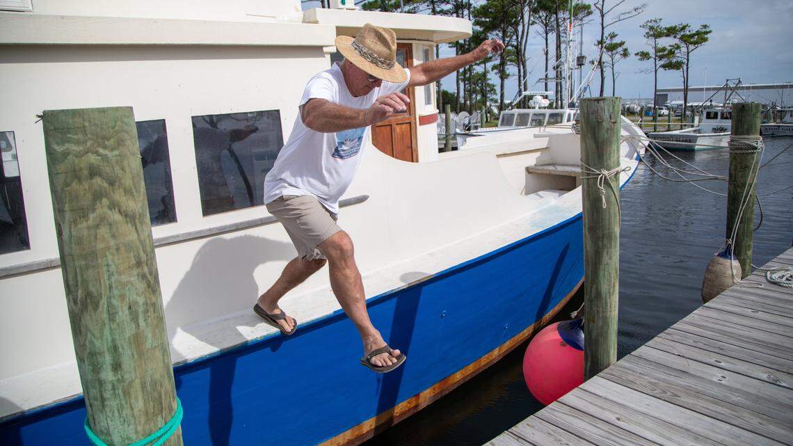 Justin Tillett, 70, jumps from his boat ‘Joy’ after securing it in Wanchese Thursday, Sept. 5, 2019 in preparation for Hurricane Dorian.