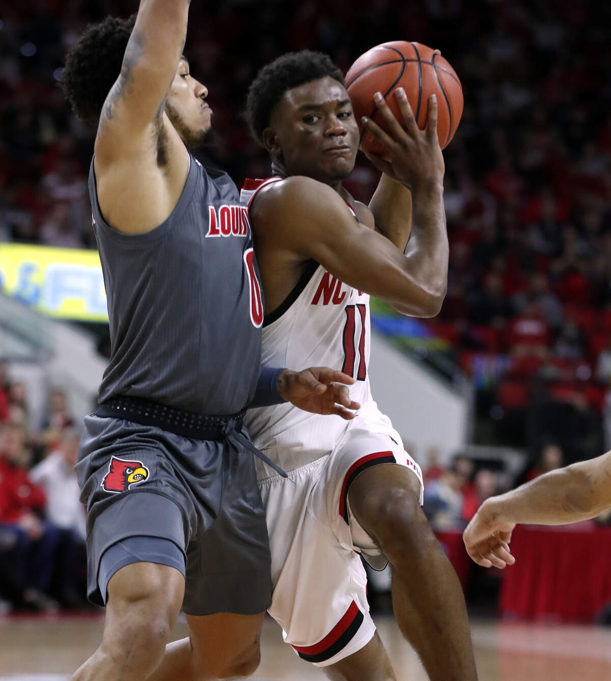 N.C. State’s Markell Johnson (11) drives around Louisville’s Lamarr Kimble (0) during the second half of Louisville’s 77-57 victory over N.C. State at PNC Arena in Raleigh, N.C., Saturday, Feb. 1, 2020.