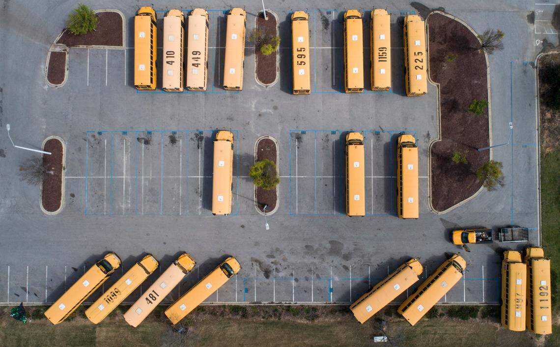 School buses sit in their designated parking lot on the empty campus of Green Hope High School in Cary, N.C. on the afternoon of Thursday, March 26, 2020. Wake County Public Schools have been closed since March 15 to curb the spread of COVID-19.