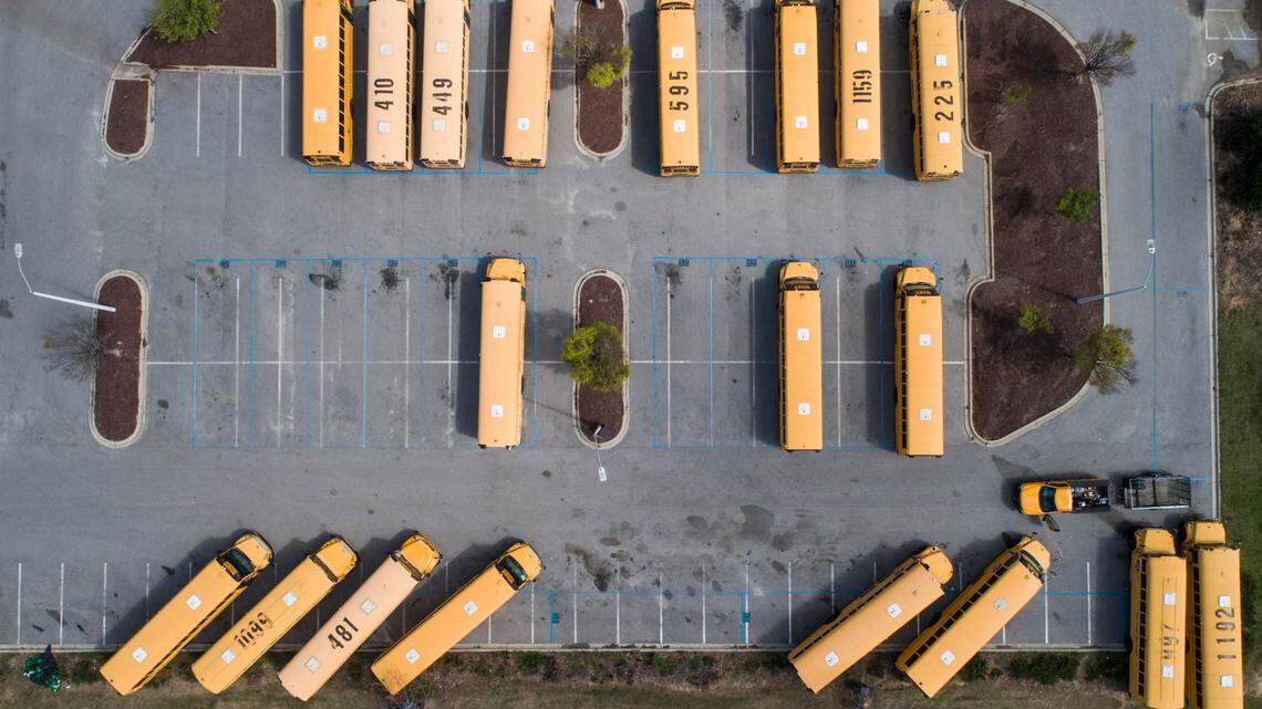 School buses sit in their designated parking lot on the empty campus of Green Hope High School in Cary, N.C. on the afternoon of Thursday, March 26, 2020. Wake County Public Schools have been closed since March 15 to curb the spread of COVID-19.