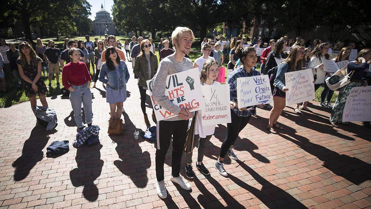 UNC-Chapel Hill students listen to survivors of sexual assault tell their stories and criticize the university’s response to sexual assault on campus in front of South Building at the #BelieveSurvivors rally this month.