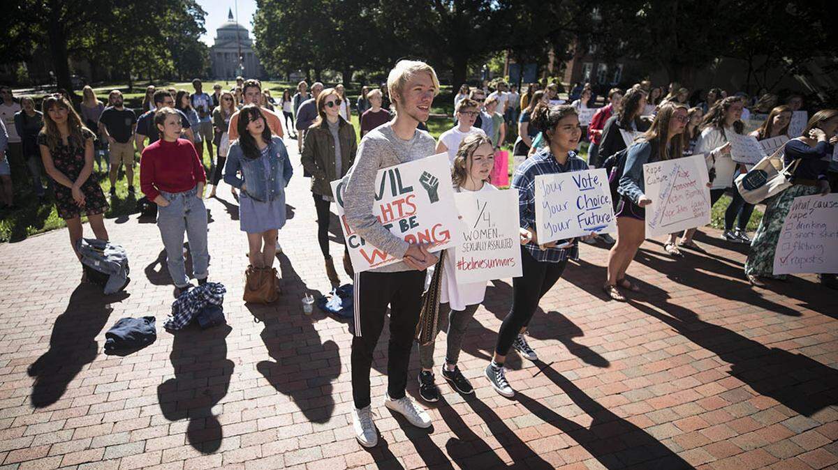 UNC-Chapel Hill students listen to survivors of sexual assault tell their stories and criticize the university’s response to sexual assault on campus in front of South Building at the #BelieveSurvivors rally in October 2018.