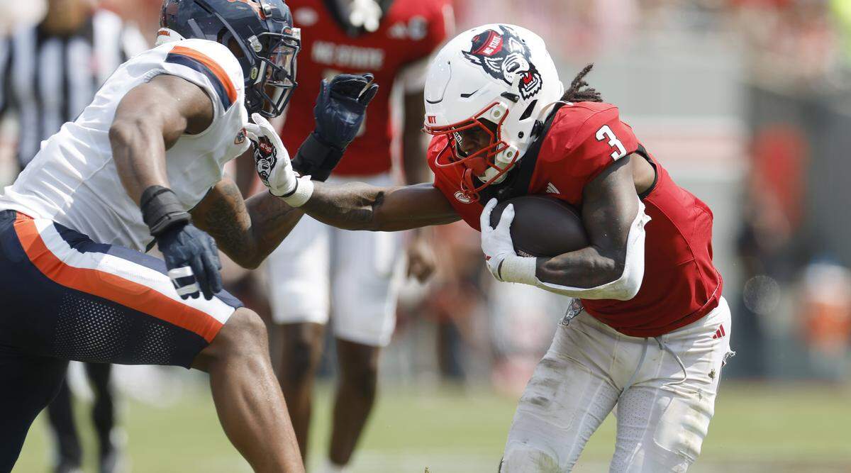 N.C. State running back Hollywood Smothers (3) stiff-arms a Virginia defender during the second half of N.C. State’s 35-31 victory over Virginia at Carter-Finley Stadium in Raleigh, N.C., Sat. Sept. 6, 2025.