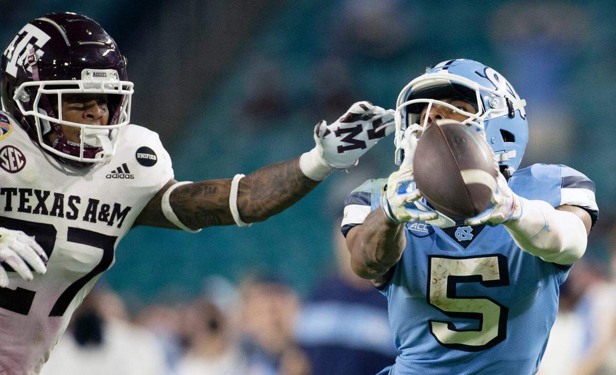 Texas A&M’s Antonio Johnson defends (27) North Carolina’s Dazz Newsome (5) on a deep pass from quarterback Sam Howell in the fourth quarter during the Capital One Orange Bowl on Saturday, January 2, 2021in Miami Gardens, Florida. 