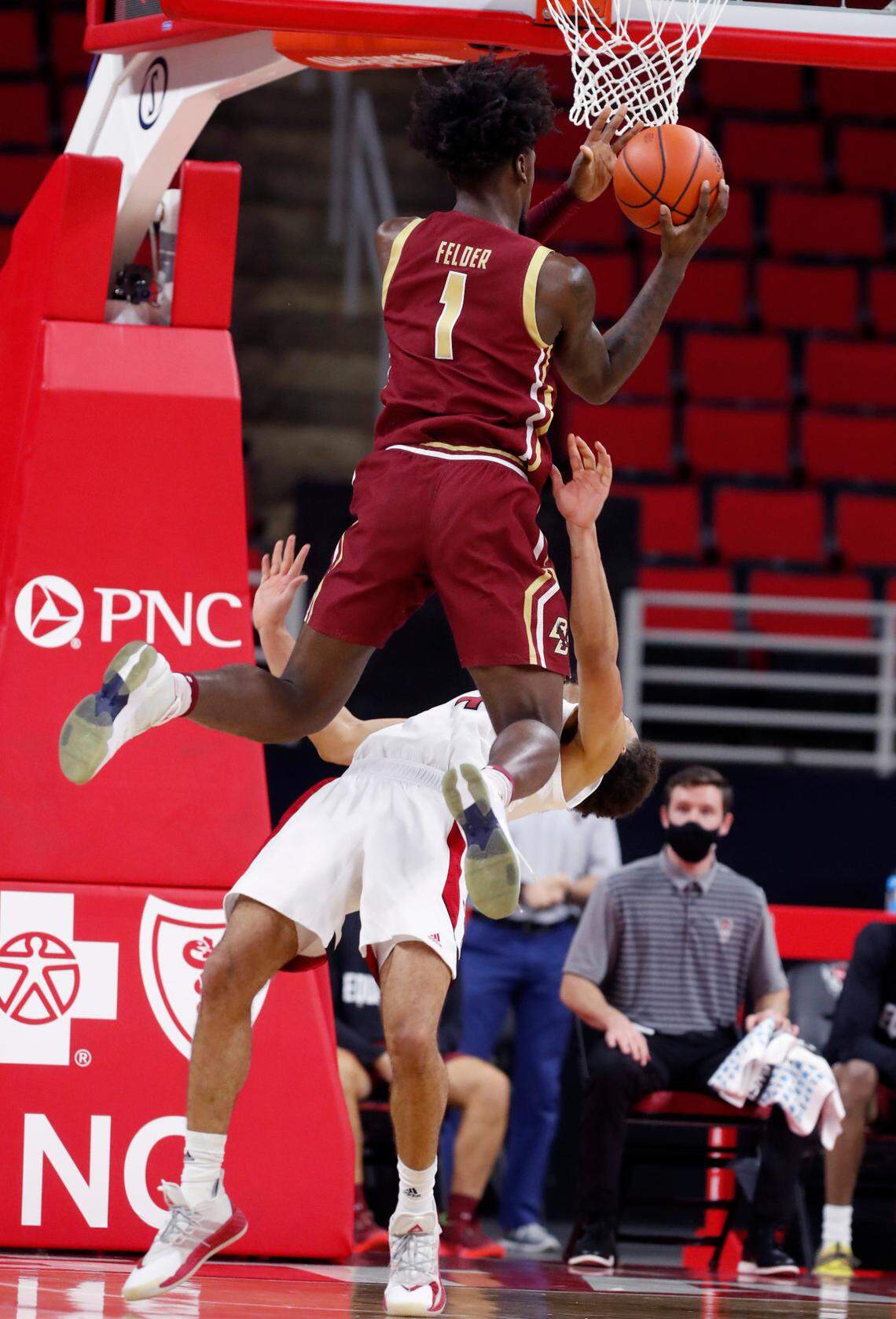 N.C. State’s Jericole Hellems (4) takes the charge by Boston College’s CJ Felder (1) during the second half of N.C. State’s 79-76 victory over Boston College at PNC Arena in Raleigh, N.C., Wednesday, December 30, 2020.