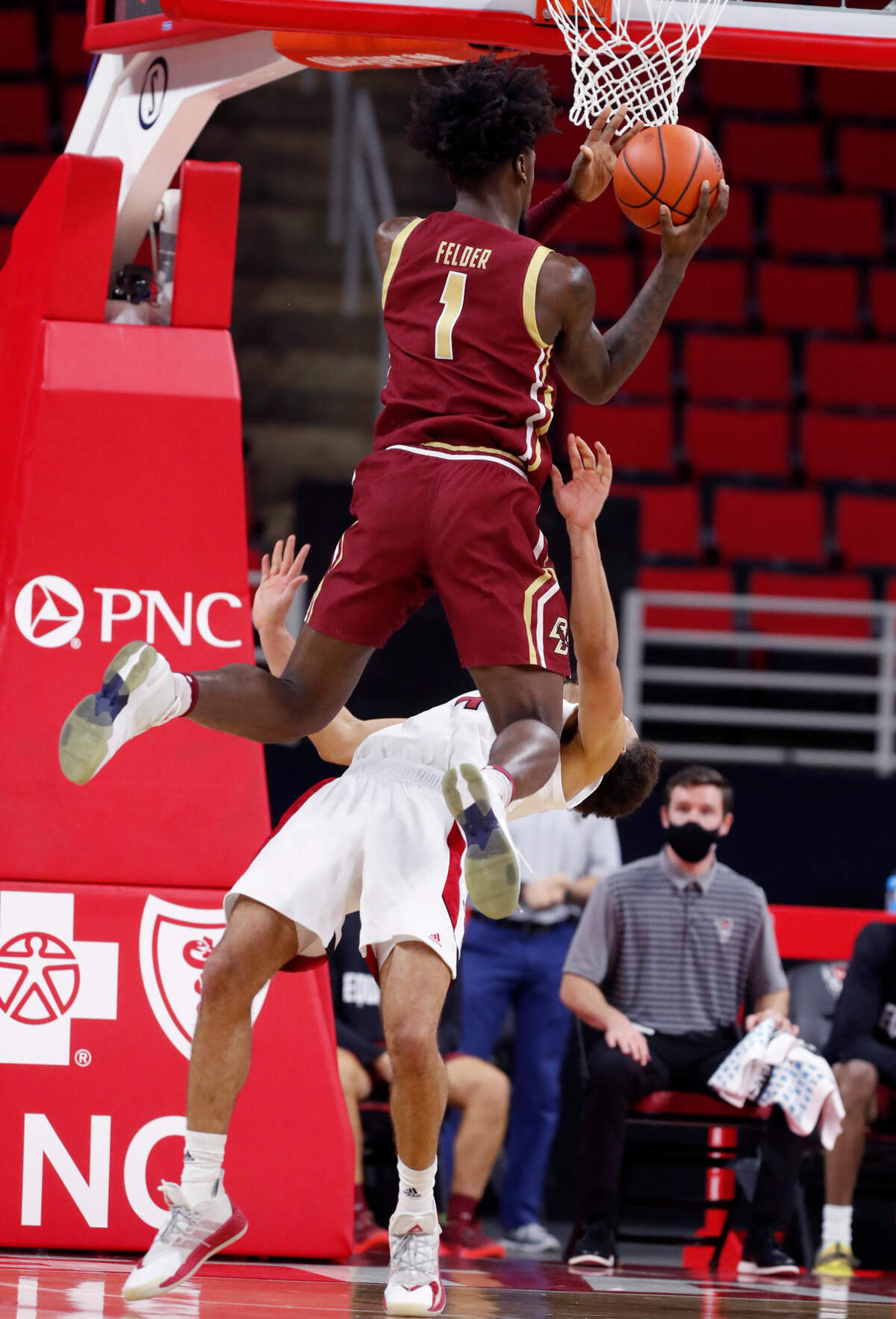 N.C. State’s Jericole Hellems (4) takes the charge by Boston College’s CJ Felder (1) during the second half of N.C. State’s 79-76 victory over Boston College at PNC Arena in Raleigh, N.C., Wednesday, December 30, 2020.