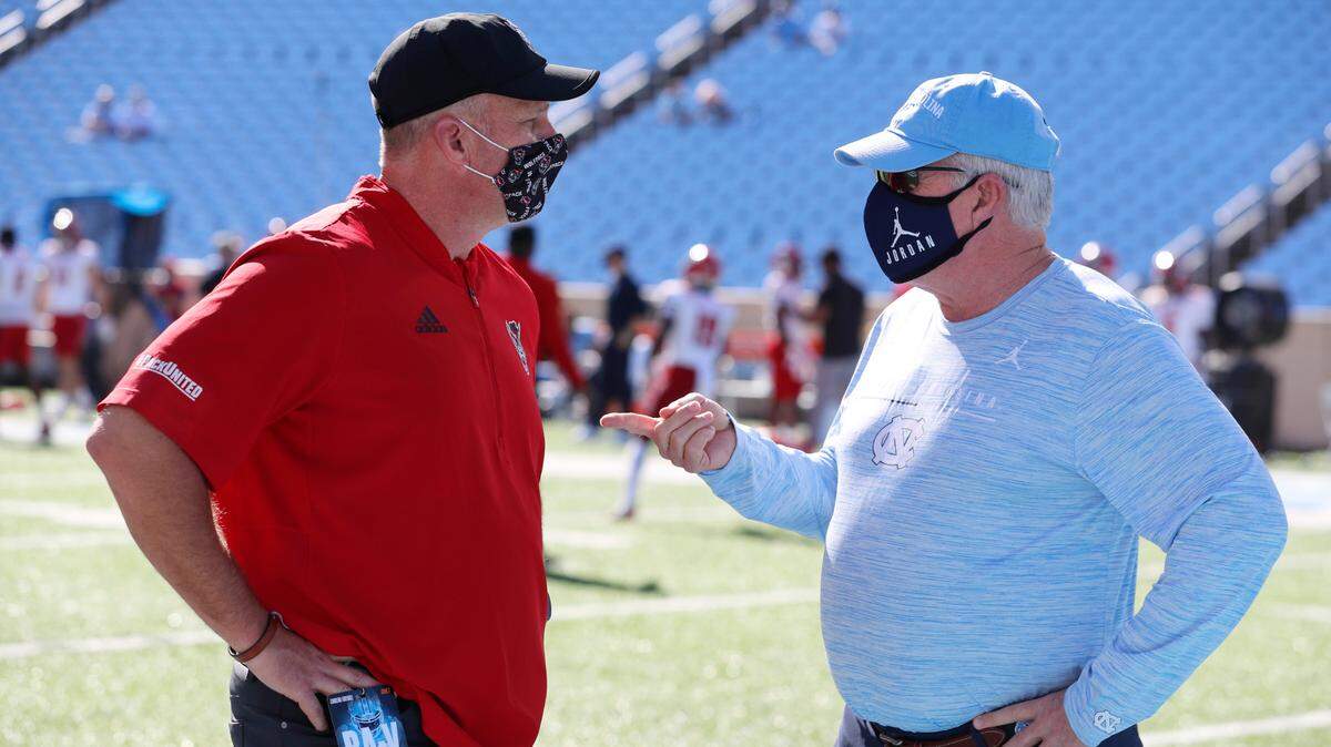 N.C. State head coach Dave Doeren, left, talks with North Carolina head coach Mack Brown before N.C. State’s game against UNC at Kenan Stadium in Chapel Hill, N.C., Saturday, Oct. 24, 2020.