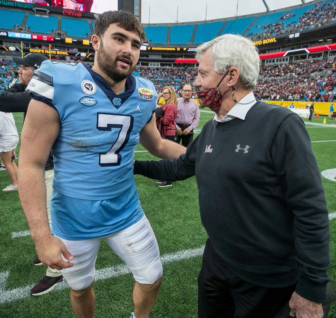 North Carolina quarterback Sam Howell embraces former Virginia Tech coach Frank Beamer, the father of South Carolina coach Shane Beamer following the Gamecocks’ 38-21 victory over North Carolina on Thursday, December 30, 2021 at Bank of America Stadium in Charlotte, N.C.