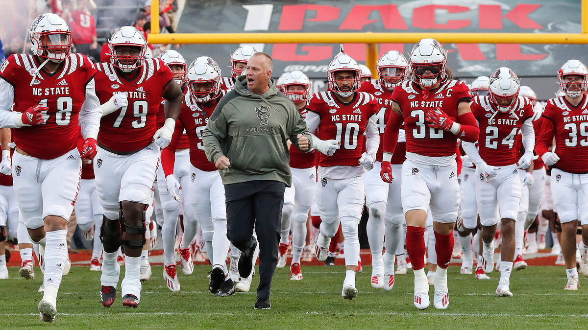 N.C. State head coach Dave Doeren runs out with the team before N.C. State’s 41-17 victory over Syracuse at Carter-Finley Stadium in Raleigh, N.C., Saturday, Nov. 20, 2021.
