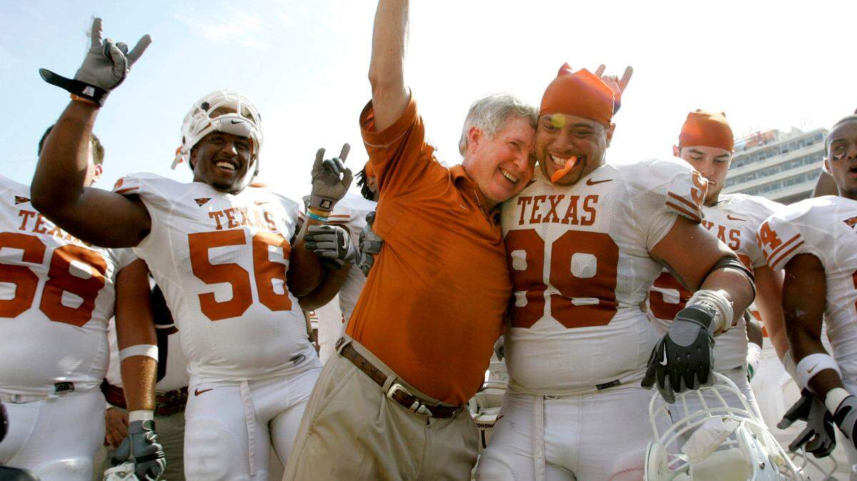Texas coach Mack Brown celebrates with Roy Miller (99) and others after beating No. 1 Oklahoma during a game in 2008, in Dallas.