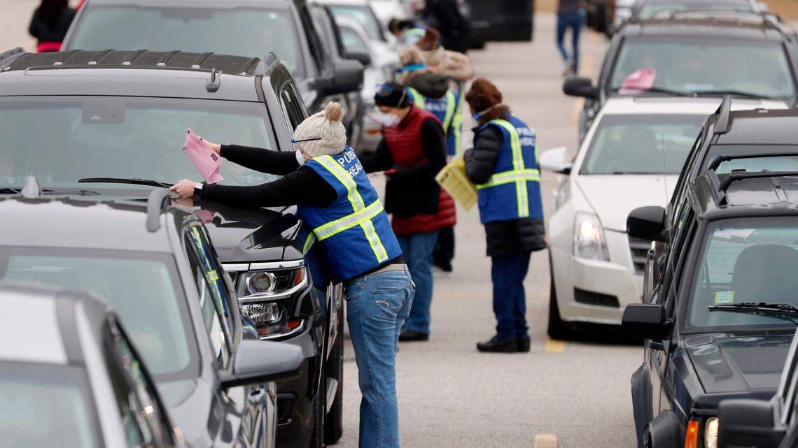 Registration information is collected from seniors lined up in their vehicles to get their COVID vaccine shot during a drive-thru COVID vaccination clinic at North Johnston High School in Kenly, N.C., Thursday, January 14, 2021.