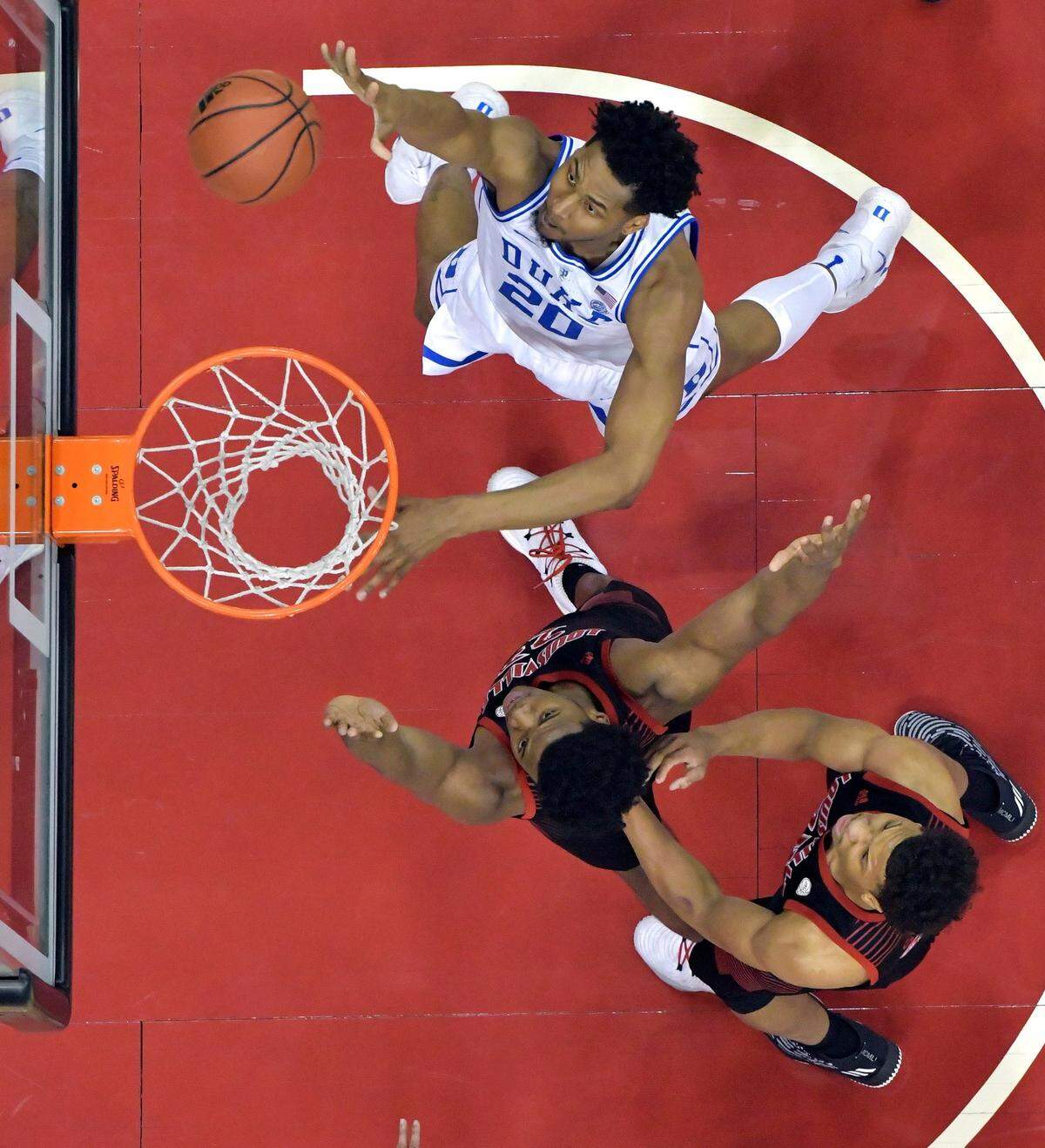 Duke center Marques Bolden (20) shoots next to Louisville center Steven Enoch, center, and forward Dwayne Sutton during the first half of an NCAA college basketball game in Louisville, Ky., Tuesday, Feb. 12, 2019. Duke won 71-69. (AP Photo/Timothy D. Easley)