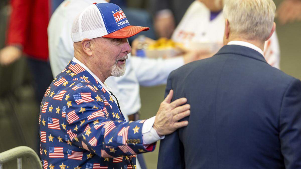Republican state Sen. Bobby Hanig, who is running in a crowded primary to challenge incumbent Democratic U.S. Rep. Don Davis in the 1st District, left, pats former Republican National Committee chair and U.S. Senate Republican primary candidate Michael Whatley on the back before a rally featuring President Donald Trump at the Rocky Mount Event Center in Rocky Mount on Friday, Dec. 19, 2025.