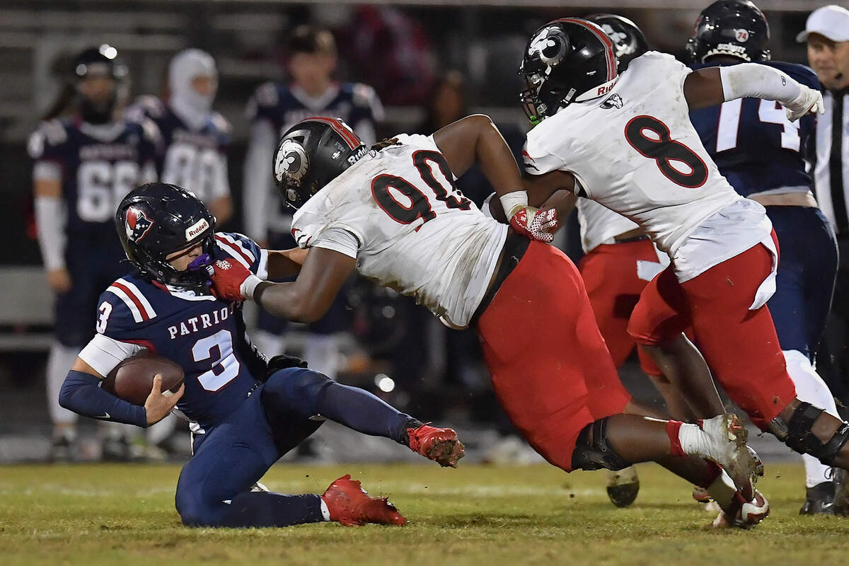 Rolesville defensive lineman Genesis Allen (90) tackles Aped Friendship quarterback Ethan McGarrigan (3)  during the second half. The Apex Friendship Patriots and the Rolesville Rams met in  the second round of the  NCHSAA 8A Playoff game in Apex, N.C. on November 14, 2025. Rolesville wins 14-7 in overtime.