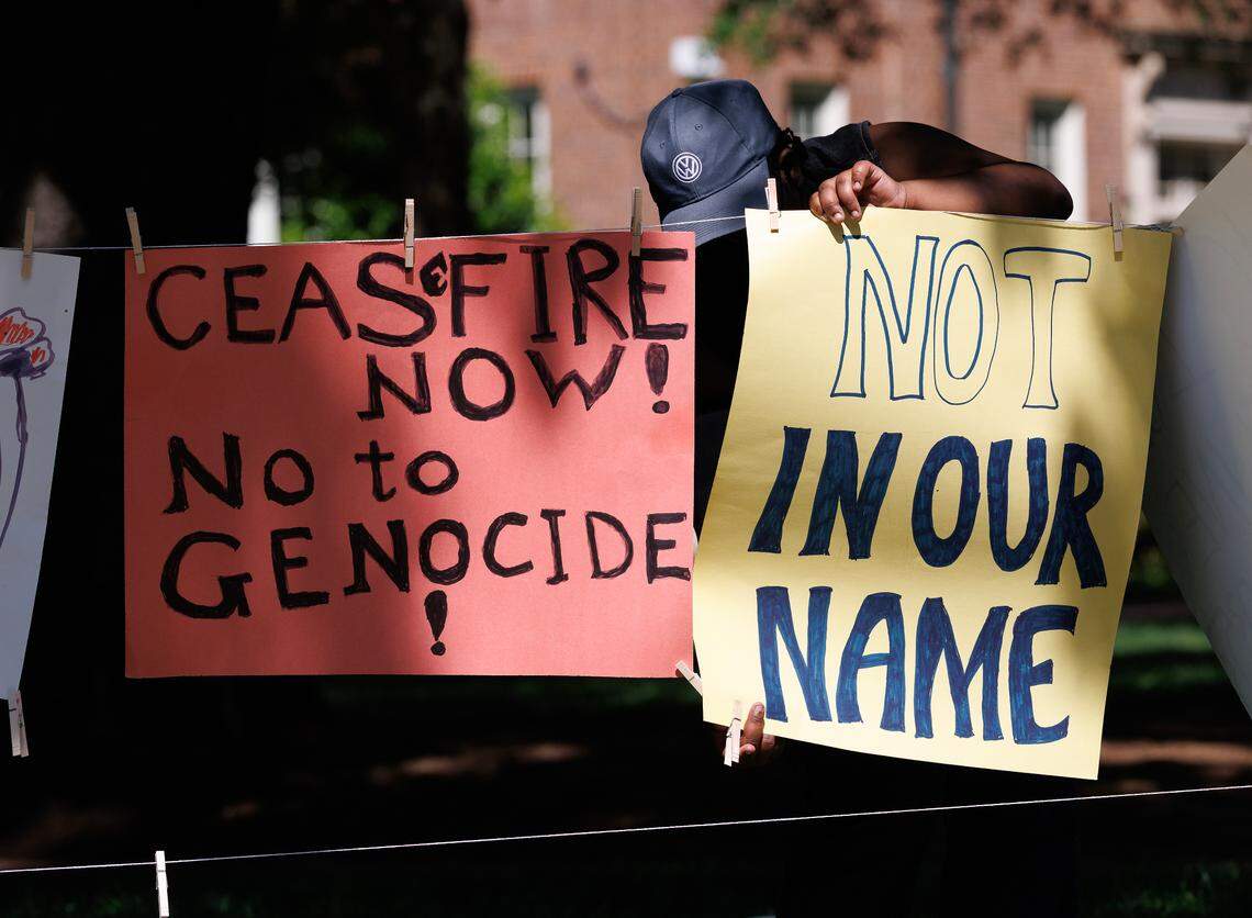 A person sets up signs on UNC-Chapel Hill’s Polk Place on Tuesday, April 29, 2025, during a gathering to mark the anniversary of the Pro-Palestinian tent encampment.