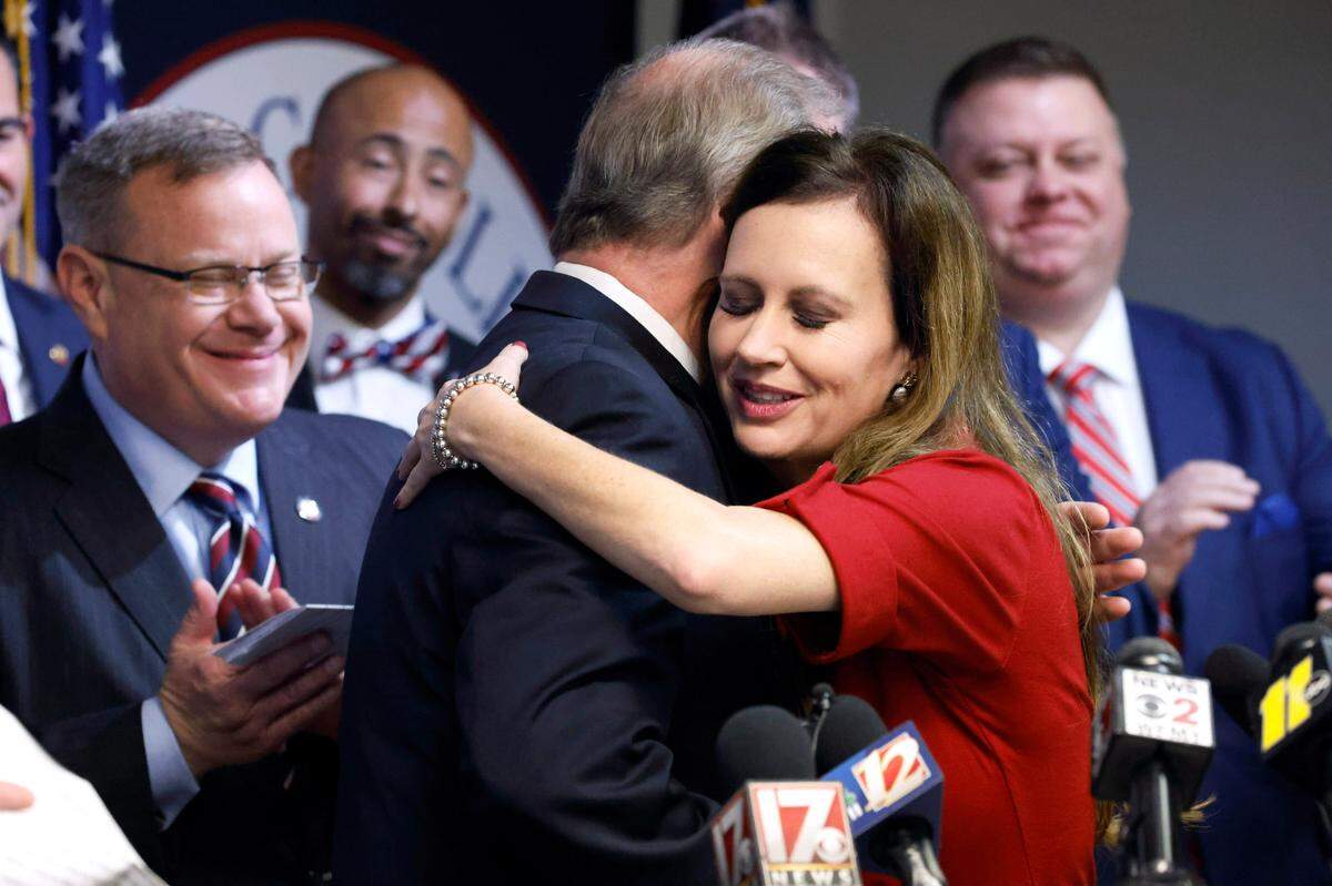 N.C. State Rep. Tricia Cotham gets a hug from N.C. Senate leader Phil Berger as N.C. House Speaker Tim Moore, left, looks on during a press conference Wednesday, April 5, 2023, announcing Rep. Cotham is switching parties to become a member of the House Republican caucus.