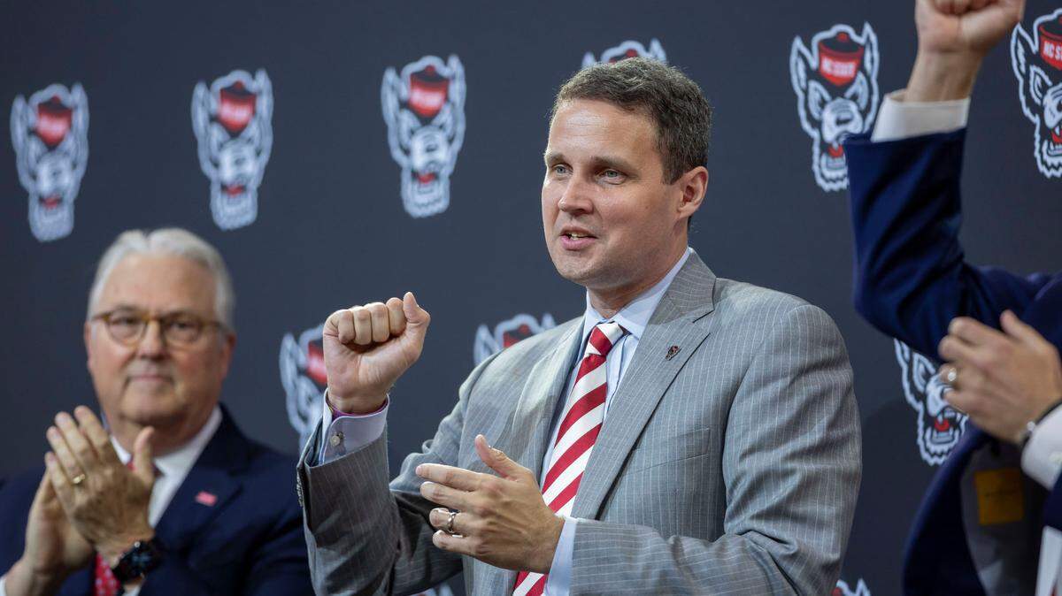 N.C. State Chancellor Randy Woodson, coach Will Wade and athletic director Boo Corrigan conclude their introduction of Wade as the new men’s basketball coach, with the Wolfpack fight song at Reynolds Coliseum on Tuesday, March 25, 2025 in Raleigh, N.C.