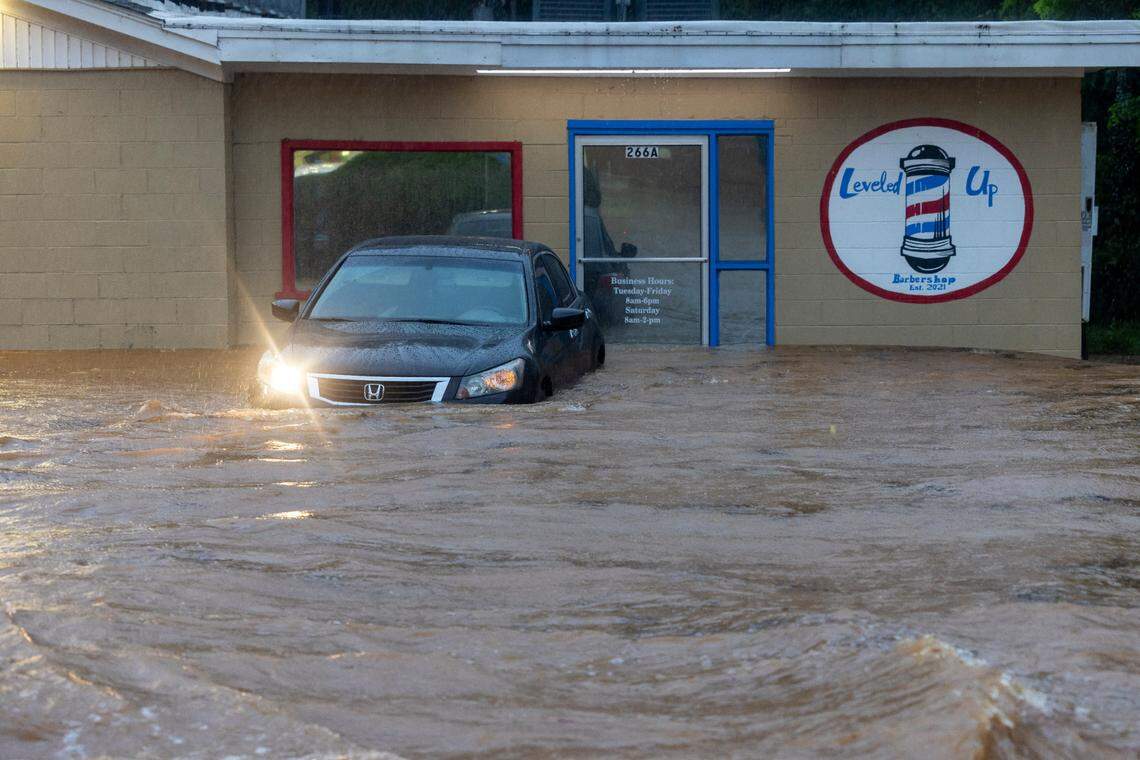 Pittsboro Elementary School Road is flooded as water flows toward Robeson Creek engulfing the Leveled Up barbershop as remnants of Tropical Storm Chantal move across the Triangle causing flash flooding on Sunday, July 6, 2025 in Pittsboro, N.C.