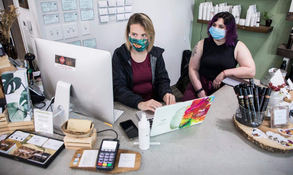 Summer Mitchell, left, and Bethany Bebik, right, sort through the many requests for appointments at Meraki Salon in Raleigh, N.C. on Thursday, May 21, 2020. Salon owner Michelle Ghassemi and her employees have been preparing to open at 50% capacity since Governor Roy Cooper announced on Wednesday that hair salons are included in Phase Two of re-opening North Carolina.