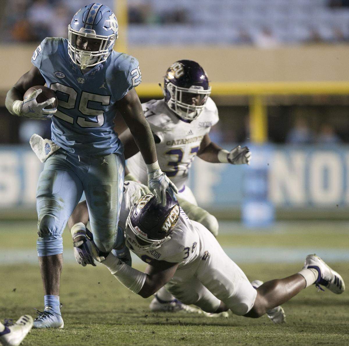Western Carolina’s Jarquavius Wortham (38) tries to stop North Carolina’s Javonte Williams (25) on an11-yards carry in the third quarter on Saturday, November 17, 2018 at Kenan Stadium in Chapel Hill.