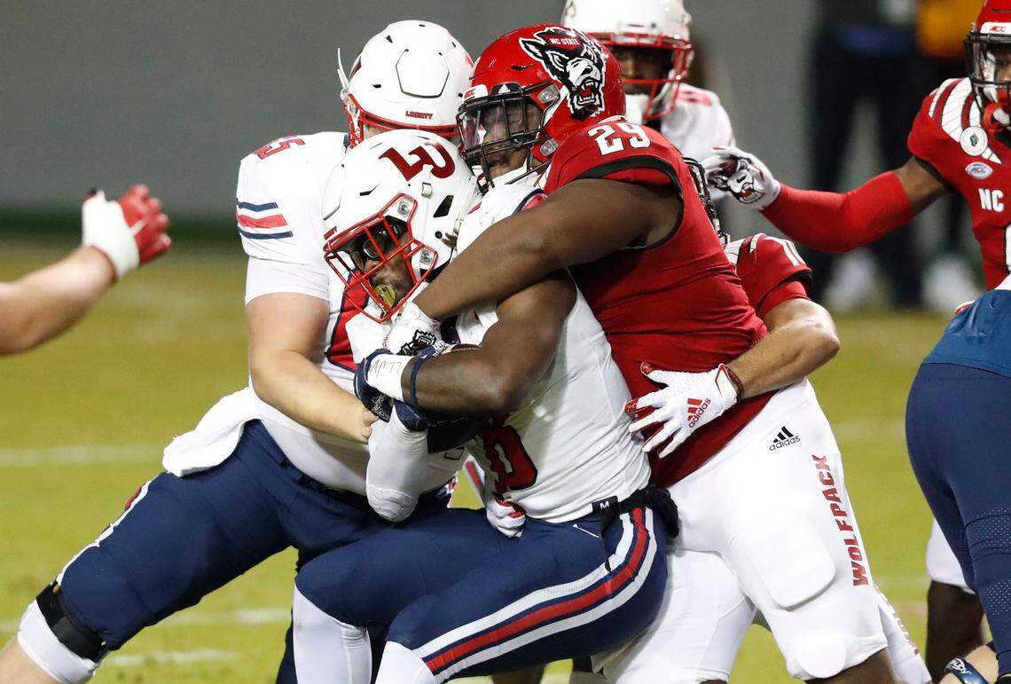N.C. State defensive tackle Alim McNeill (29) stops Liberty running back Joshua Mack (8) during the first half of N.C. State’s game against Liberty at Carter-Finley Stadium in Raleigh, N.C., Saturday, Nov. 21, 2020.
