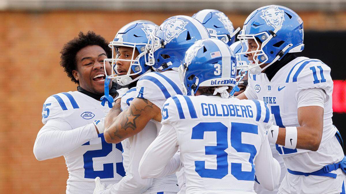 Teammates swarm Jordan Moore after he scored a touchdown as time expired to give the Blue Devils a 23-17 victory over Wake Forest at Allegacy Stadium on Saturday, Nov. 30, 2024, in Winston-Salem, N.C.