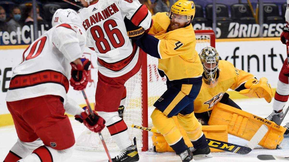 Nashville Predators defenseman Ryan Ellis (4) shoves Carolina Hurricanes left wing Teuvo Teravainen (86) away from the puck during the first period of an NHL hockey game Saturday, May 8, 2021, in Nashville, Tenn. (AP Photo/Mark Zaleski)