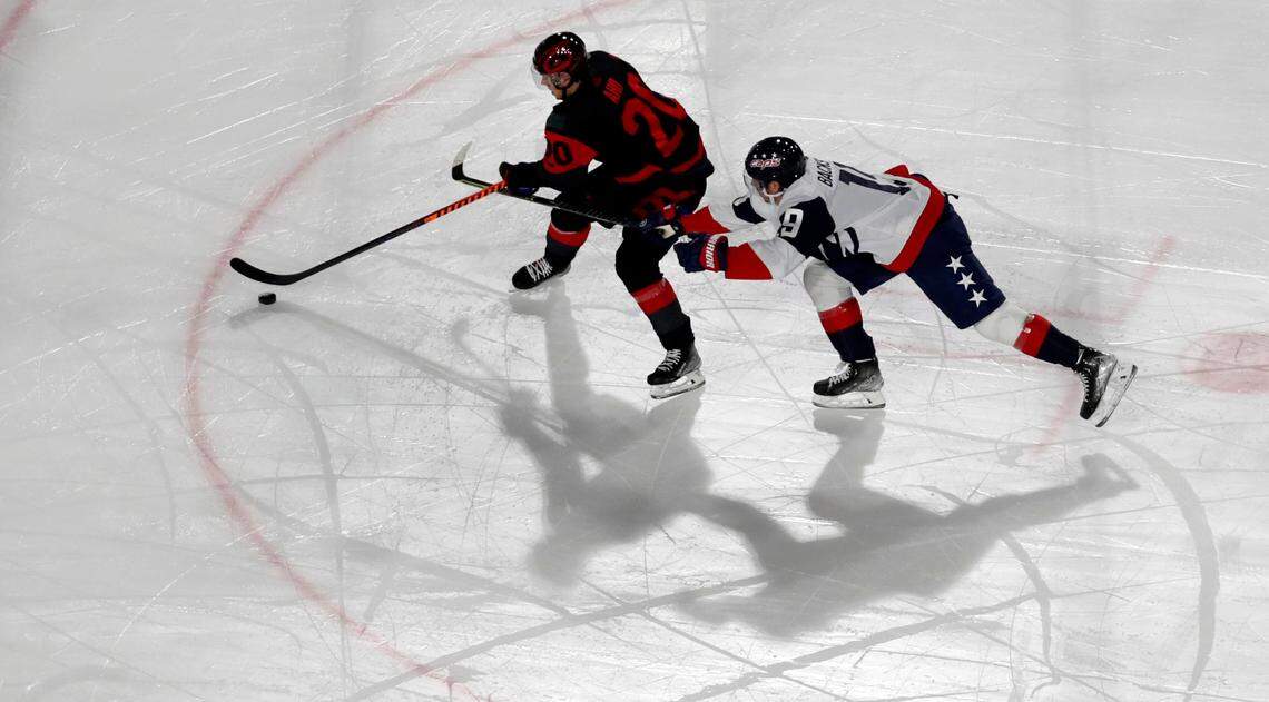 Washington center Nicklas Backstrom (19) tries to slow down Carolina center Sebastian Aho (20) during the first period of the NHL Stadium Series game between the teams at Carter-Finley Stadium in Raleigh, N.C., Saturday, Feb. 18, 2023.