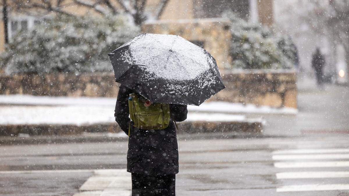 A woman’s umbrella begins to accumulate snow near UNC-Chapel Hill on Wednesday, Feb. 19, 2024.