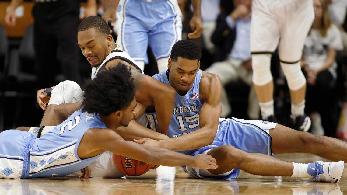 North Carolina’s Coby White, front and Garrison Brooks, right, try and recover a loose ball away from Wofford’s Cameron Jackson, back, during the first half of an NCAA college basketball game in Spartanburg, S.C., Tuesday, Nov. 6, 2018.