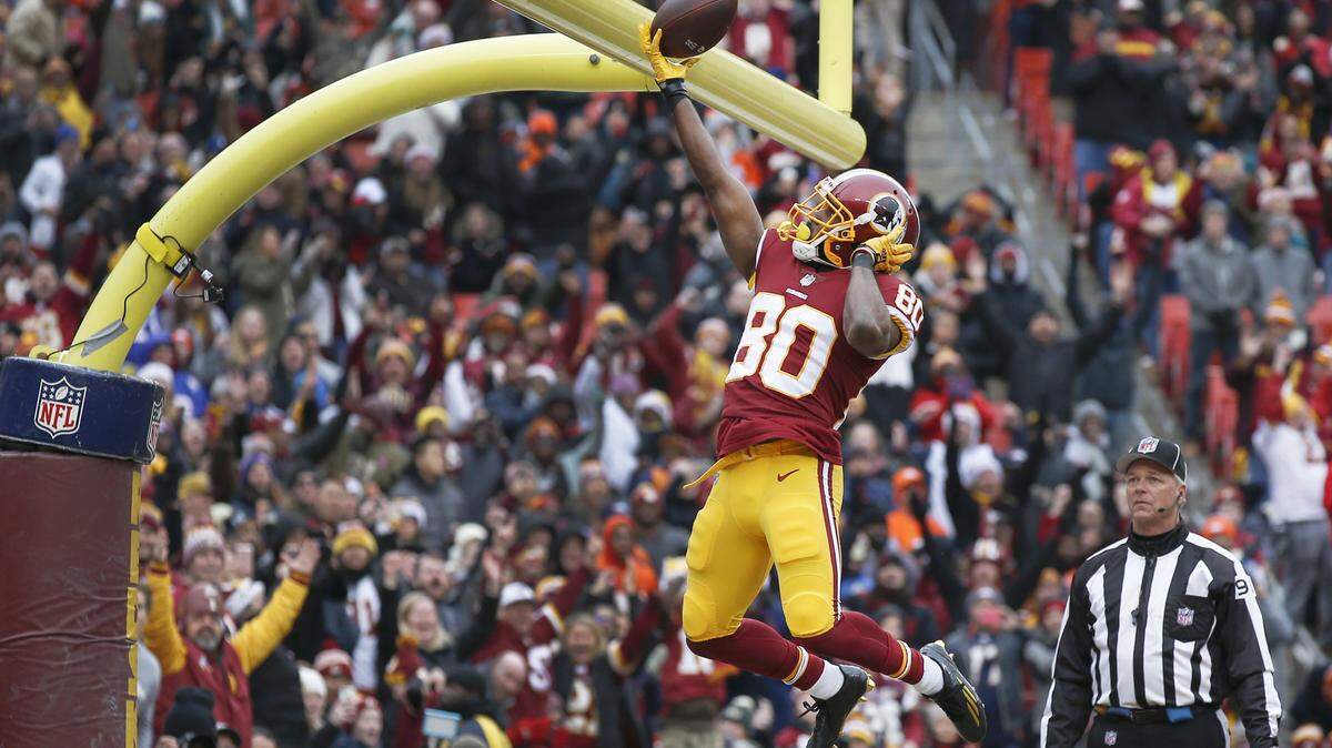 Washington Redskins wide receiver Jamison Crowder (80) celebrates his touchdown by dunking the ball over the goal posts during the first half an NFL football game against the Denver Broncos in Landover, Md., Sunday, Dec 24, 2017. 