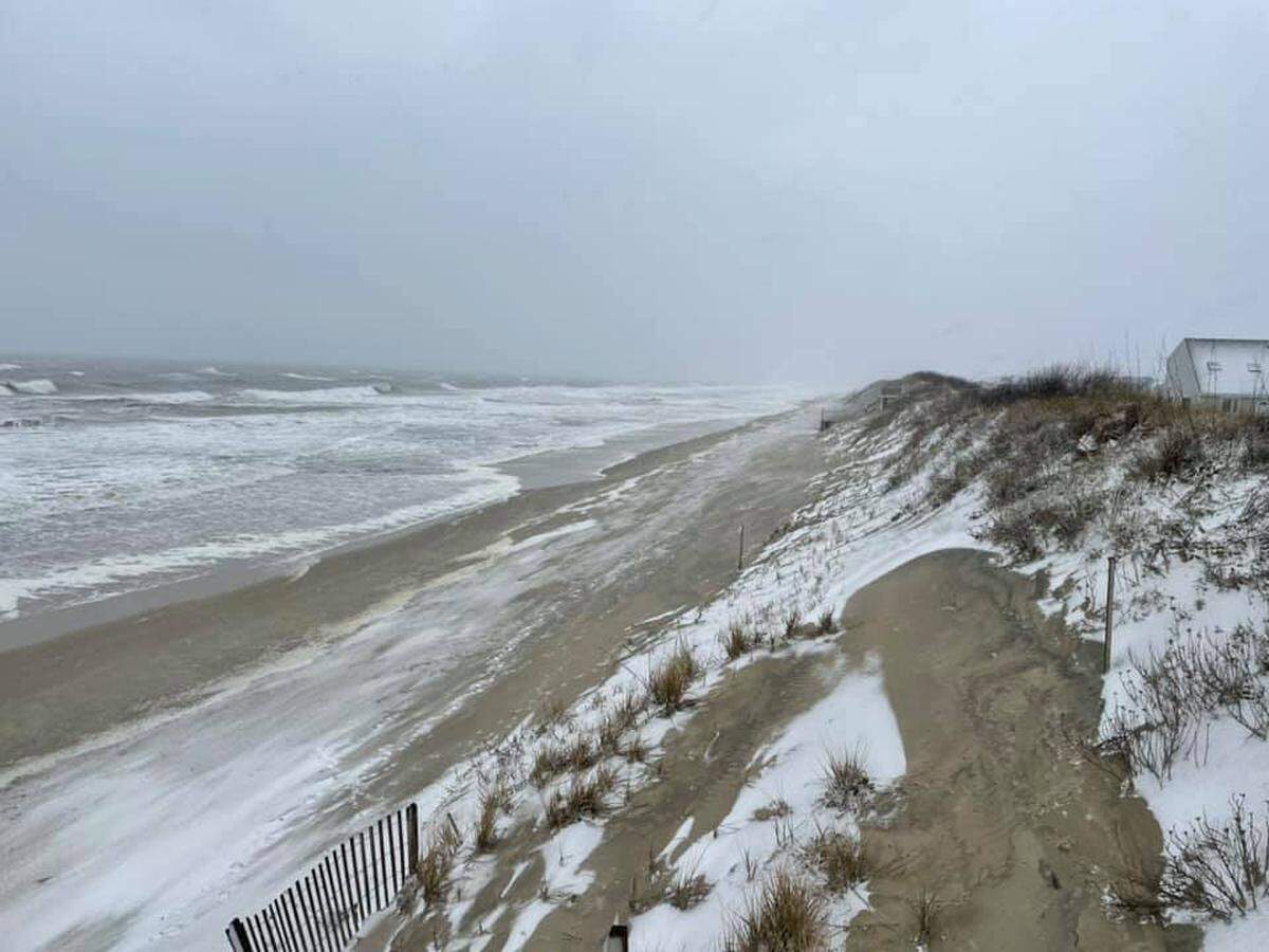 Snow fell early Thursday on North Carolina’s Outer Banks, creating a surreal scenes of sea winds scouring beaches with a wintry mix of snow flakes and sand.