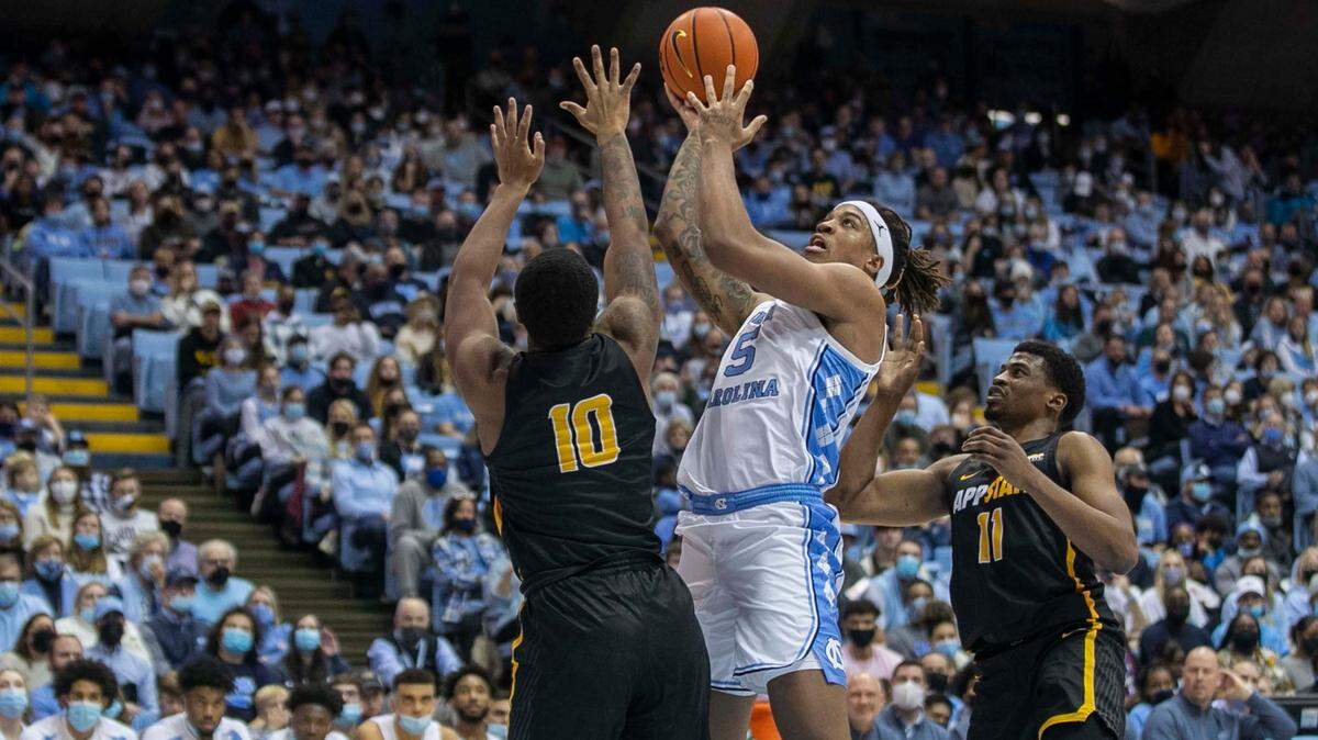 North Carolina’s Armando Bacot (5) drives to the basket against Appalachian State’s Michael Eads Jr. (10) and Donovan Gregory (11) during the first half on Tuesday, December 21, 2021 at the Smith Center in Chapel Hill, N.C. Bacot lead the Tar Heels with 16 points in their 70-50 victory.