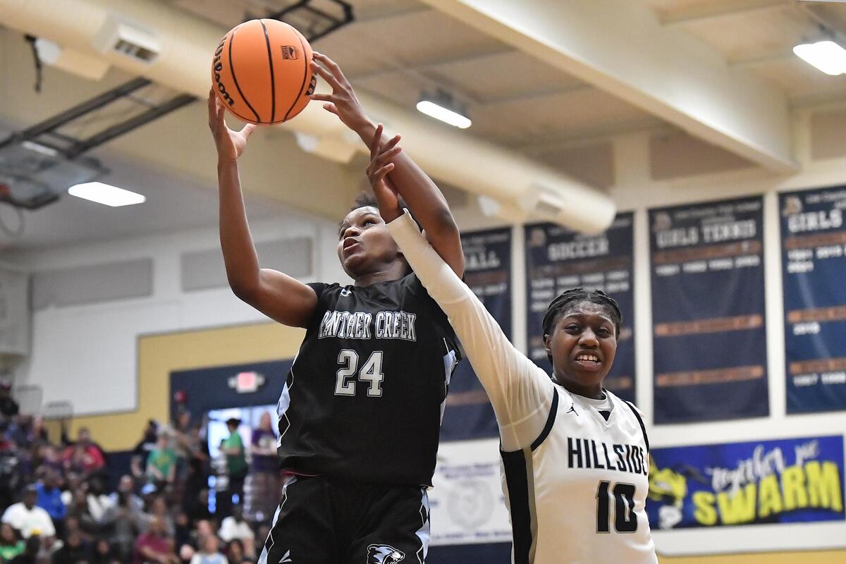 Panther Creek’s Kirstin Smalls (24) secures the rebound against Hillside’s Dorinda Jordan (10) during the first half. The Hillside Hornets and the Panther Creek Catamounts met in the NCHSAA 4A East Regional Finals in Sanford, N.C. on March 4, 2023.
