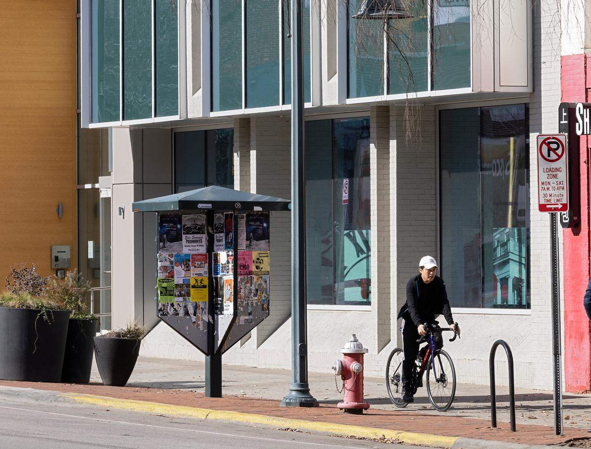 A cyclist rides by 137 East Franklin Street, a building that will become a part of Chapel Hill’s new downtown innovation district, on Friday, Jan. 20, 2023.