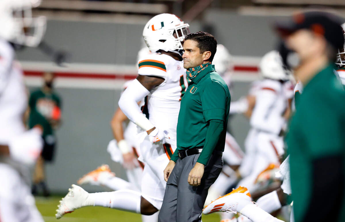 Miami head coach Manny Diaz watches his players warm up before N.C. State’s game against Miami at Carter-Finley Stadium in Raleigh, N.C., Friday, Nov. 6, 2020.