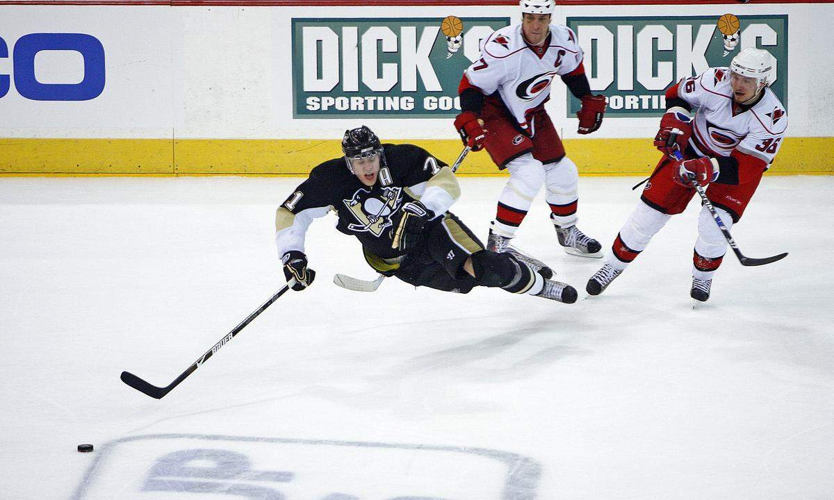 The Pittsburgh Penguins’ Evgeni Malkin (71) gets upended as he goes for the puck in front of the Carolina Hurricanes’ Rod Brind’Amour (17) and Jussi Jokinen (36) during third period action of Game 2 of the NHL Eastern Conference playoffs between the Carolina Hurricanes and the Pittsburgh Penguins played at the Mellon Arena in Pittsburgh PA on Monday May 21, 2009.
