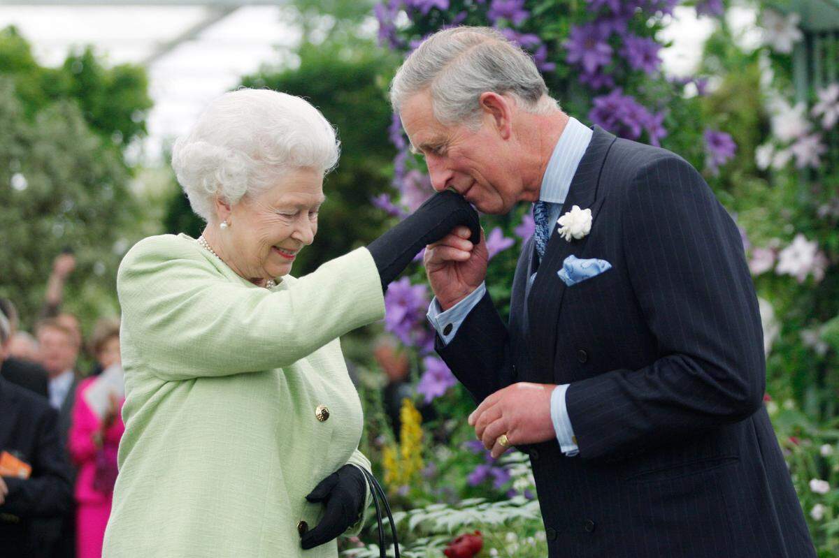 Britain Prince Charles, right, kisses the hand of his mother Queen Elizabeth II after he was presented with a Royal Horticultural Society’s Victoria Medal of Honour during a visit to Chelsea Flower Show in London, Monday, May 18, 2009. The Victoria Medal of Honour is the highest accolade that the Royal Horticultural Society can bestow.