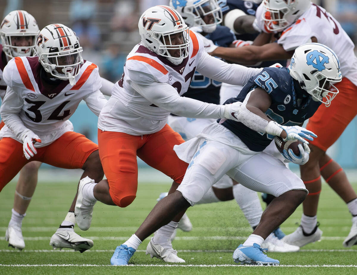 North Carolina’s Javonte Williams (25) turns the corner on Virginia Tech’s Armani Chatman (27) in the third quarter on Saturday, October 10, 2020 at Kenan Stadium in Chapel Hill, N.C.
