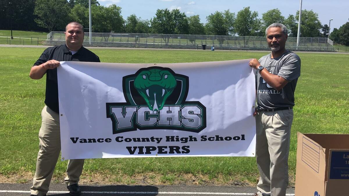 Vance County athletics director Joseph Sharrow, left, and principal Rey Horner, right, pose with the new Vance County High School Vipers logo.