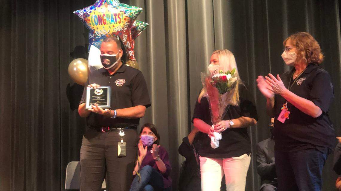 Knightdale High School principal Keith Richardson (left) holds a plaque given by assistant principals Stacy Reel (center) and Liz Stevenson (right) after being announced as the 2022 North Central Region Principal of the Year at a ceremony at the school on Dec. 17, 2021.