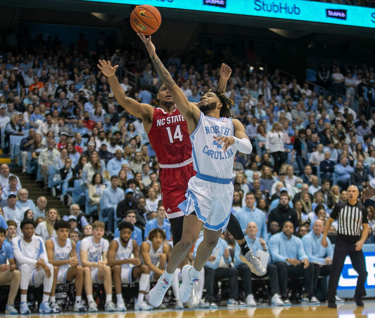 North Carolina’s R.J. Davis (4) drives to the basket against N.C. State’s Casey Morsell (14) during the second half on Saturday, January 21, 2023 at the Smith Center in Chapel Hill, N.C. Davis lead all scores with 26 points in the Tar Heels’ 80-69 victory.