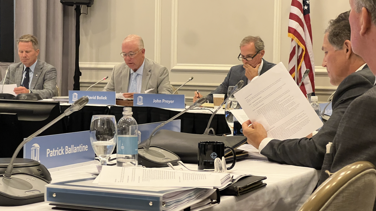 UNC-Chapel Hill Chancellor Kevin Guskiewicz (left) sits next to university’s board of trustees, David Boliek, John Preyer at a special meeting at The Carolina Inn on Thursday, June 27.
