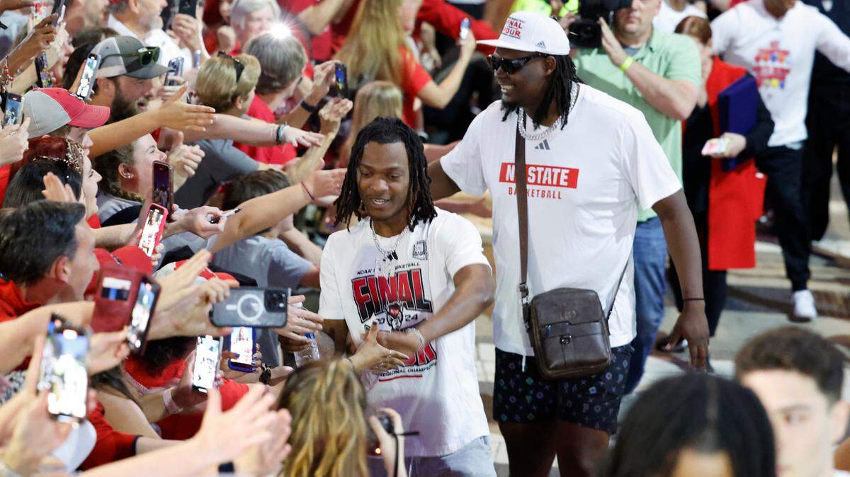 N.C. State’s DJ Horne and DJ Burns Jr. greet fans as they walk towards the belltower during a celebration for the N.C. State men’s and women’s basketball team at the Memorial Belltower in Raleigh, N.C., Monday, April 15, 2024. Both teams made it to the NCAA Tournament Final Four and the men’s team won the ACC Championship by winning five games in five days.
