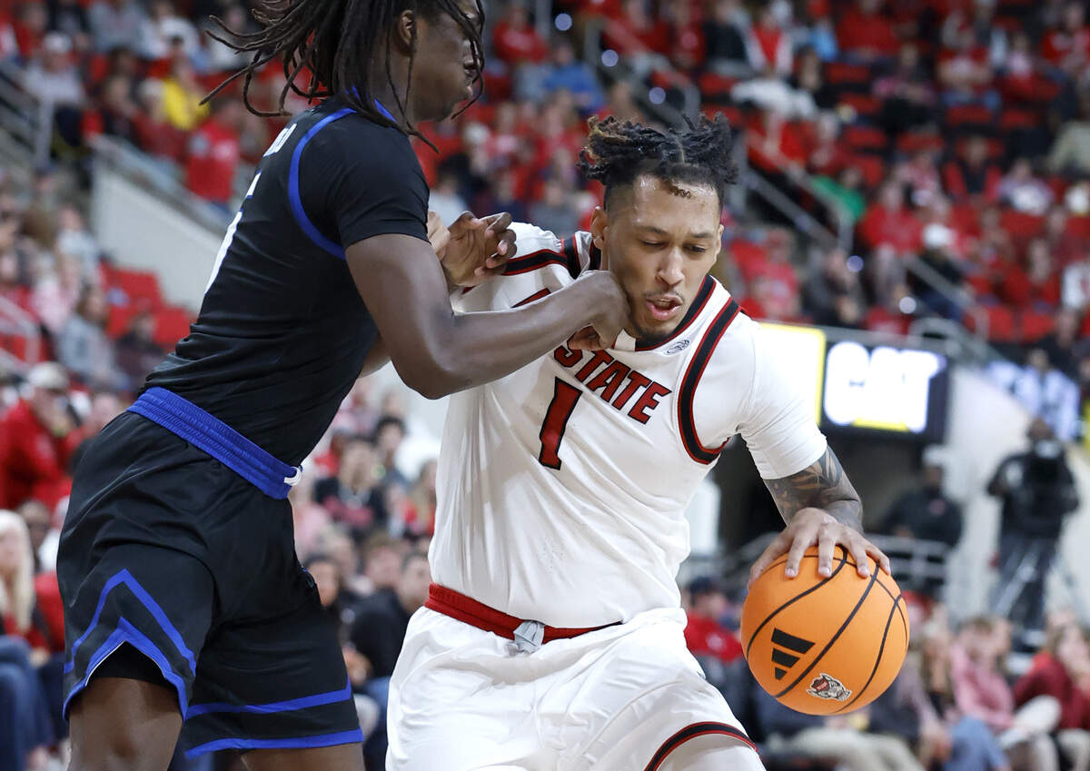 UNC Asheville's Myles Mayfield (5) fouls N.C. State's Darrion Williams (1) during the second half of N.C. State’s 75-63 victory over UNC Asheville at the Lenovo Center in Raleigh, N.C., Saturday, Dec. 6, 2025.