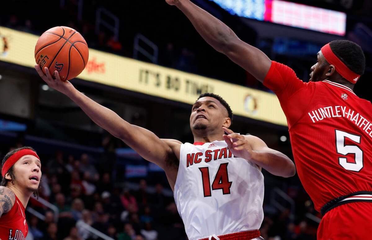 N.C. State’s Casey Morsell (14) drives to the basket past Louisville’s Brandon Huntley-Hatfield (5) during the second half of N.C. State’s 94-85 victory over Louisville in the first round of the 2024 ACC Men’s Basketball Tournament at Capital One Arena in Washington, D.C., Tuesday, March 12, 2024.