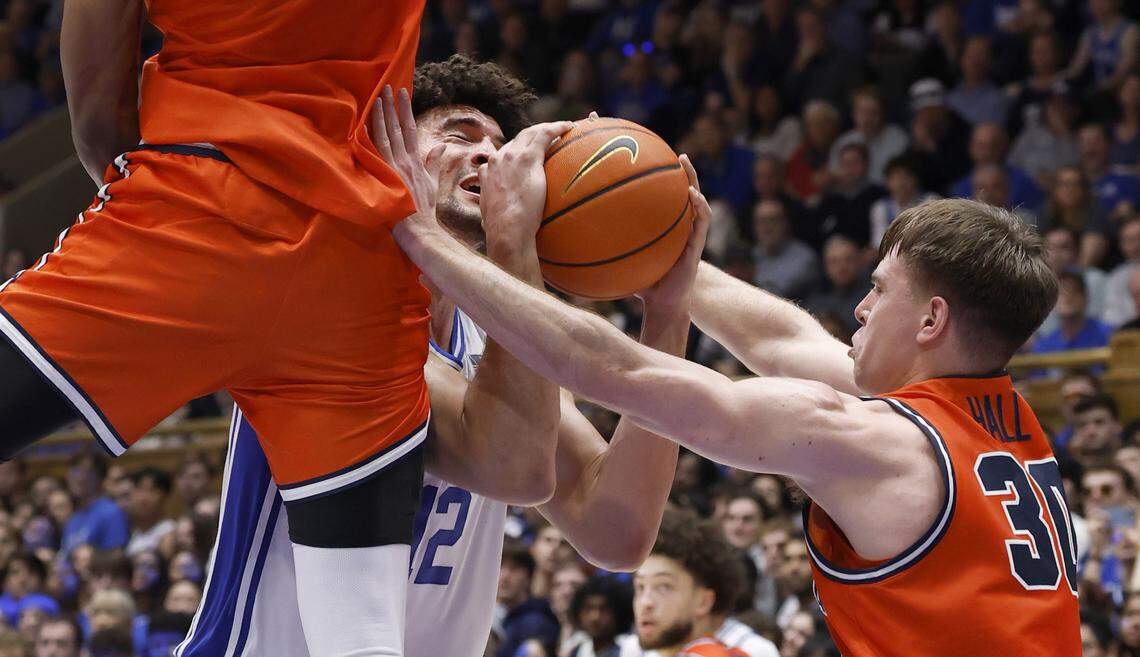 Duke’s Cameron Boozer (12) is defended by Virginia's Ugonna Onyenso (33) and Dallin Hall (30) during the first half of Duke’s game against Virginia at Cameron Indoor Stadium in Durham, N.C., Saturday, Feb. 28, 2026.