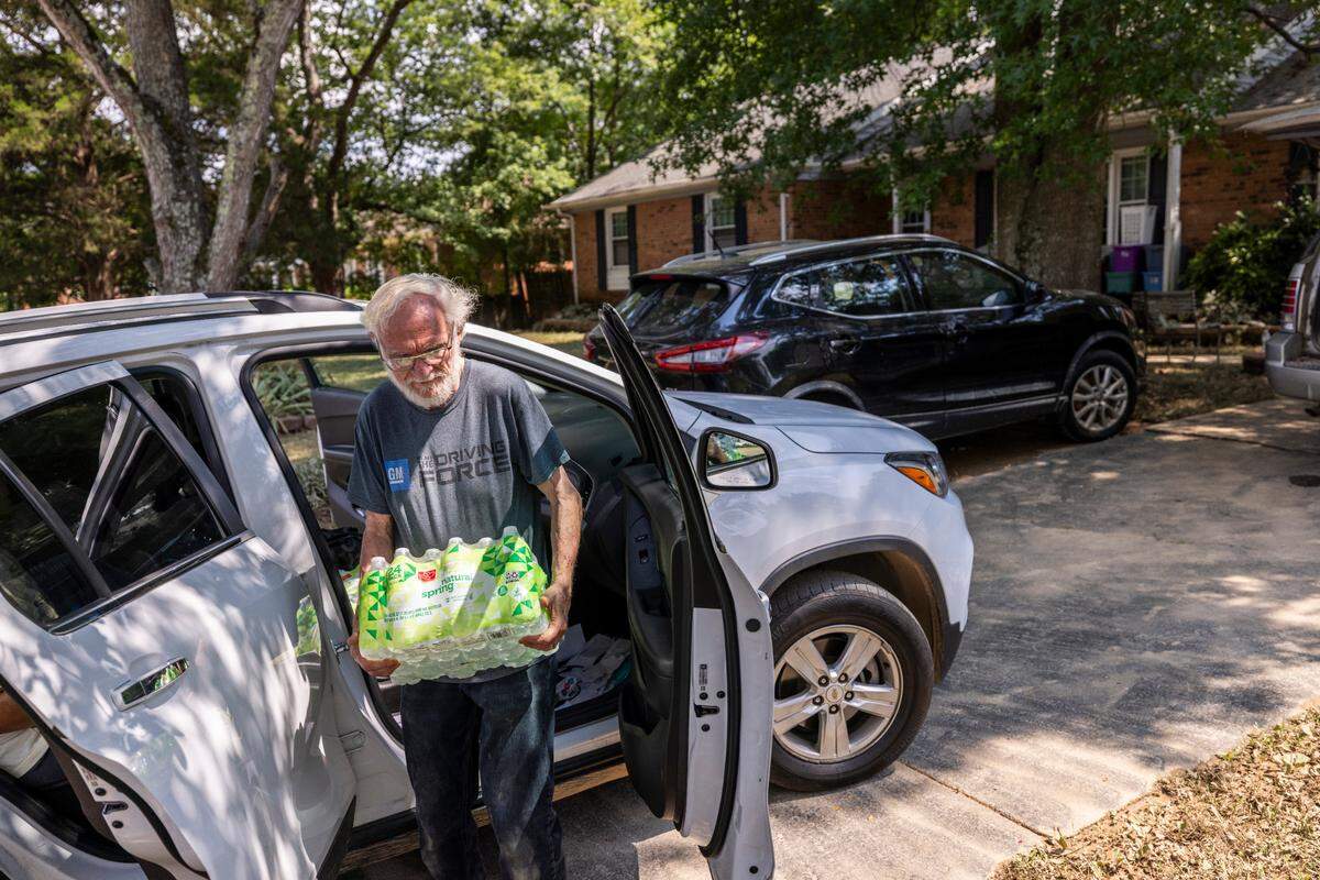 Mike Went unloads bottled water at his flood-damaged home in Durham’s Old Farm neighborhood near the Eno River on Wednesday, July 9, 2025, after flash flooding caused by Tropical Storm Chantal. Went, who lived through Hurricane Fran in 1996, said this flooding was worse.