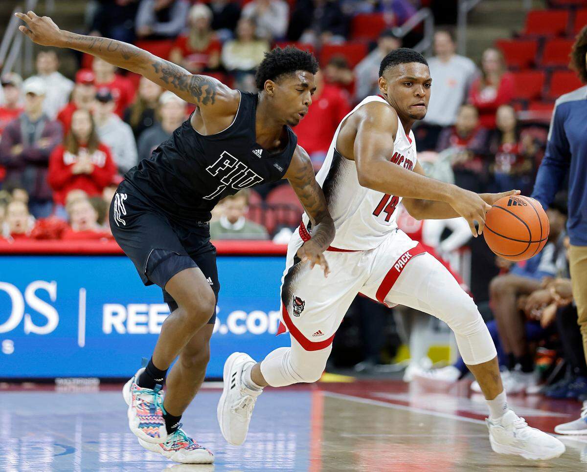 North Carolina State Wolfpack guard Casey Morsell pushes the ball past Florida International Golden Panthers guard Dashon Gittens during the second half of a men’s basketball game at PNC Arena on Tuesday, Nov. 15, 2022, in Raleigh, N.C.