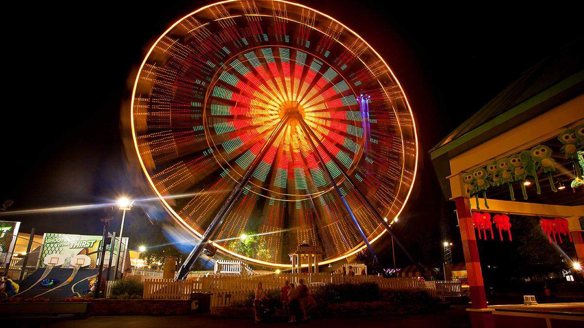 The Americana, a 110-foot tall Ferris wheel, is a flash of color against a night sky over Kings Dominion theme park in Virginia. The park is about a three-hour drive from the Triangle. 